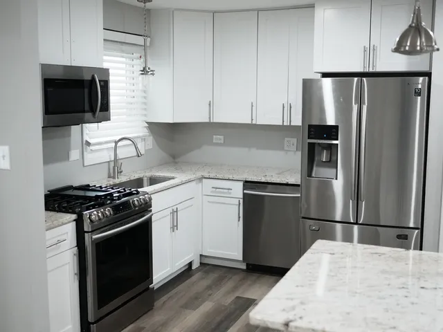 a kitchen with stainless steel appliances a refrigerator stove and microwave