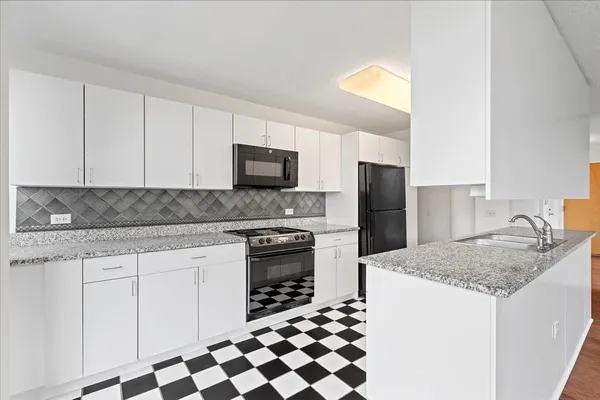 a kitchen with stainless steel appliances granite countertop a stove a sink and a microwave