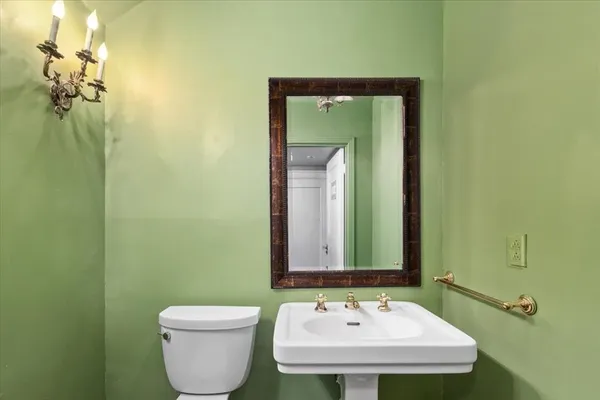 a bathroom with a toilet a sink and mirror