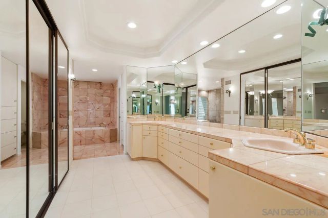 a large bathroom with a large mirror vanity and shower
