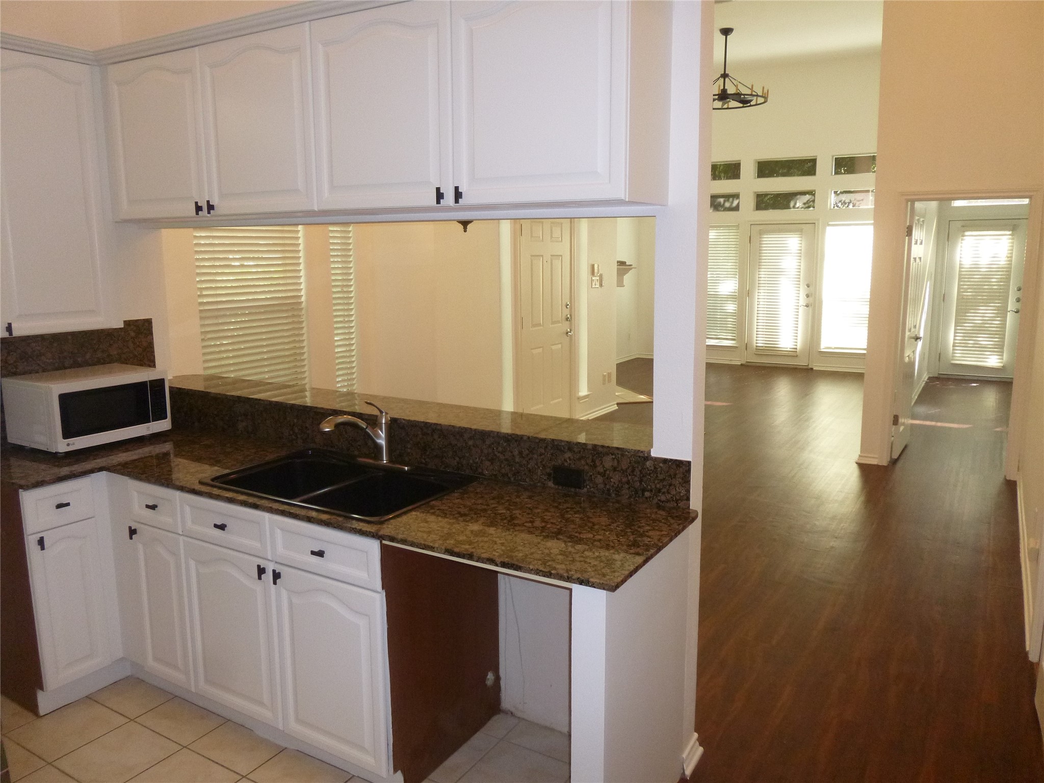 2918 Ranch Road 620 North, Unit Y194 Austin, TX 78734 - Photo 12 of 35 a kitchen with granite countertop a sink and white cabinets