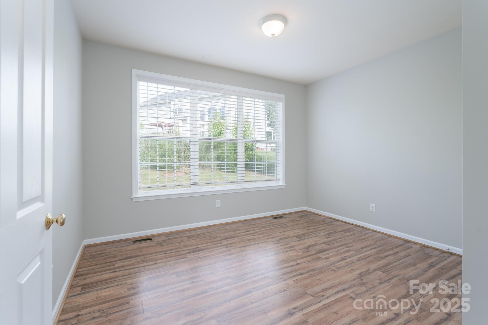 4392 Sunset Rose Drive Fort Mill, SC 29708 - Photo 11 of 39 a view of an empty room with wooden floor and a window