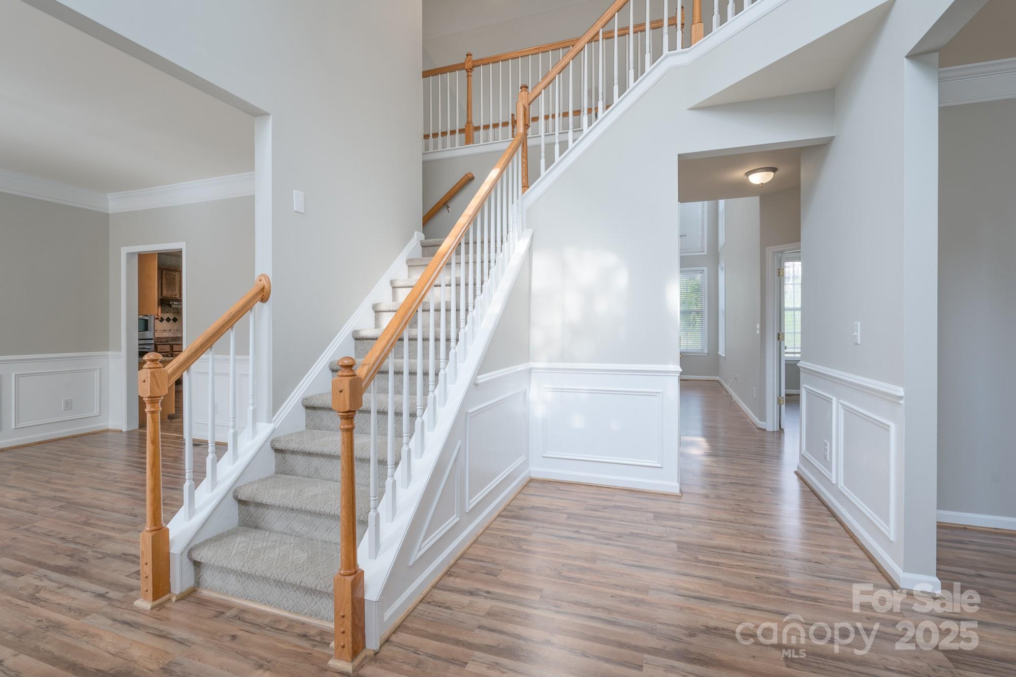 4392 Sunset Rose Drive Fort Mill, SC 29708 - Photo 15 of 39 a view of staircase with wooden floor and a chandelier
