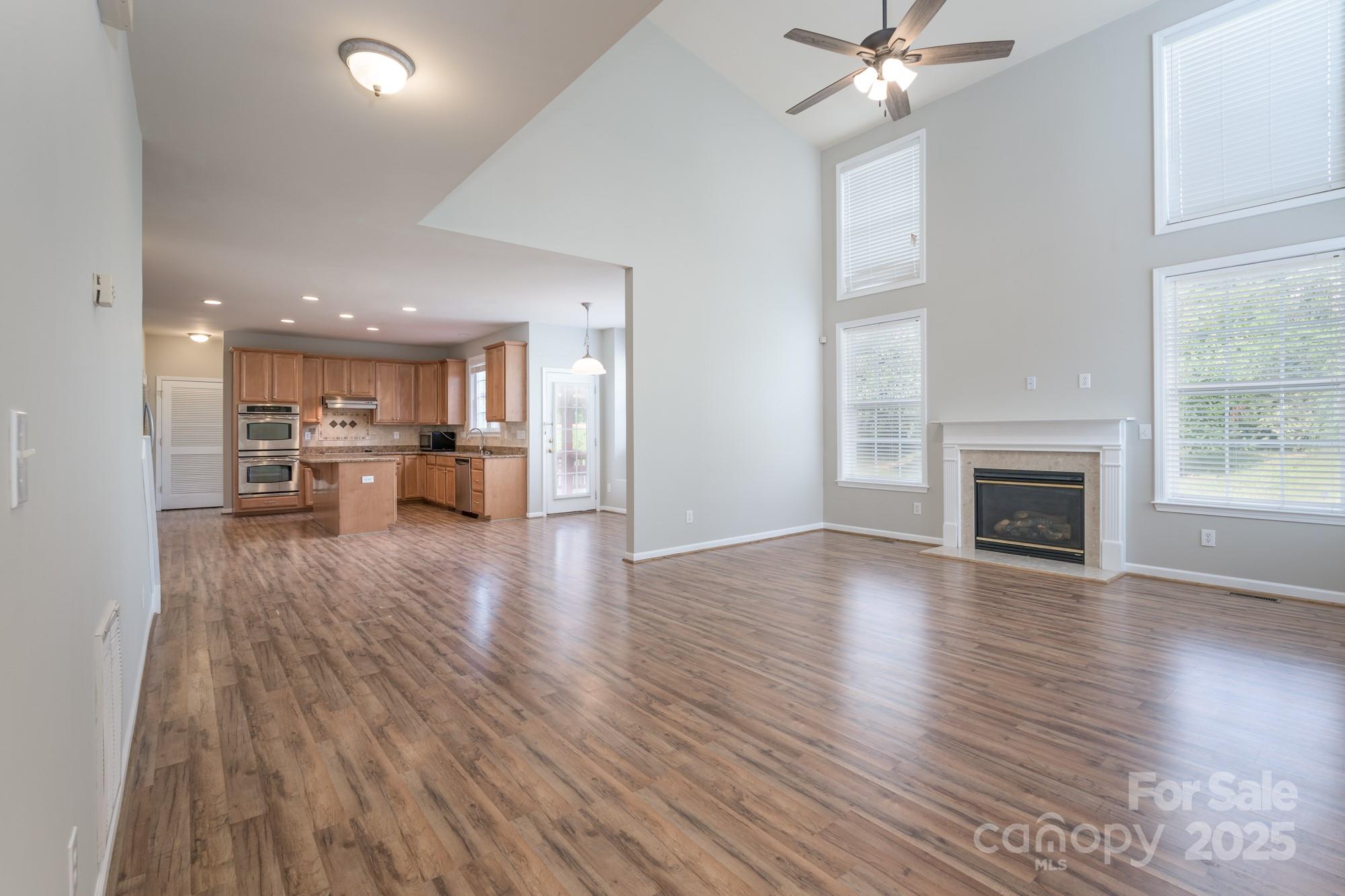 4392 Sunset Rose Drive Fort Mill, SC 29708 - Photo 3 of 39 a view of a living room a kitchen with wooden floor and a fireplace