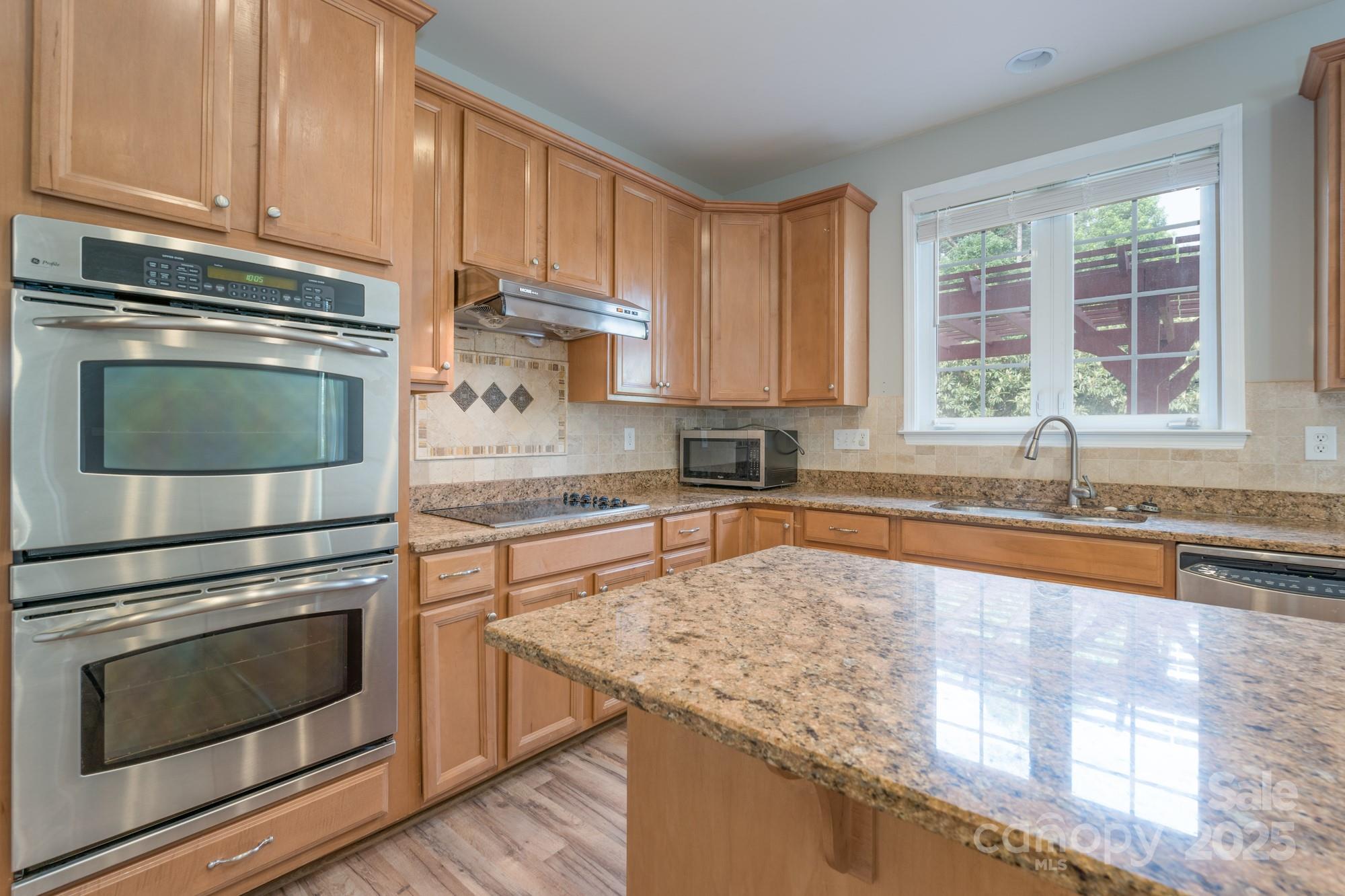 4392 Sunset Rose Drive Fort Mill, SC 29708 - Photo 6 of 39 a kitchen with granite countertop wooden cabinets appliances and a window