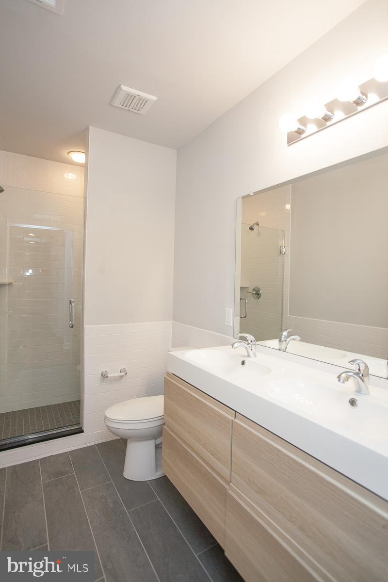 5938 Henry Avenue, Unit 21 Philadelphia, PA 19128 - Photo 16 of 19 a bathroom with a sink a toilet and shower