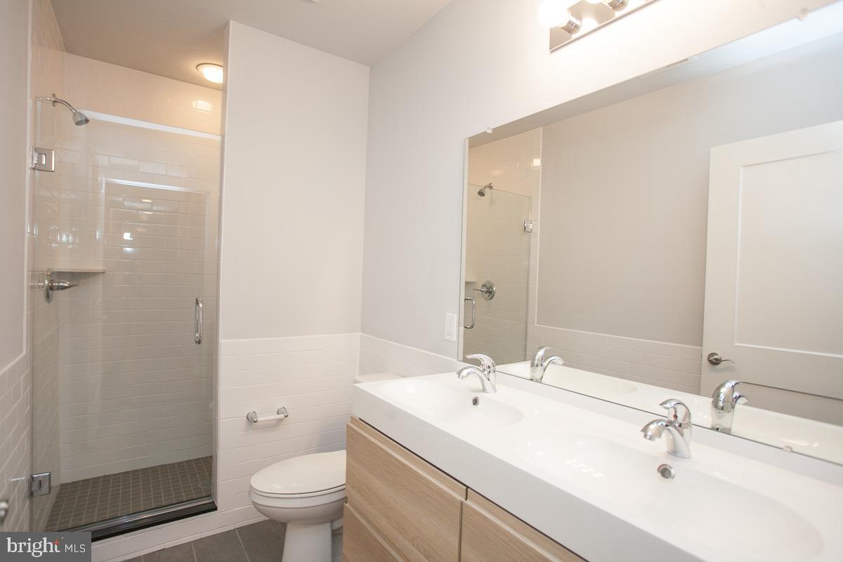 5938 Henry Avenue, Unit 21 Philadelphia, PA 19128 - Photo 17 of 19 a bathroom with a sink a toilet and shower