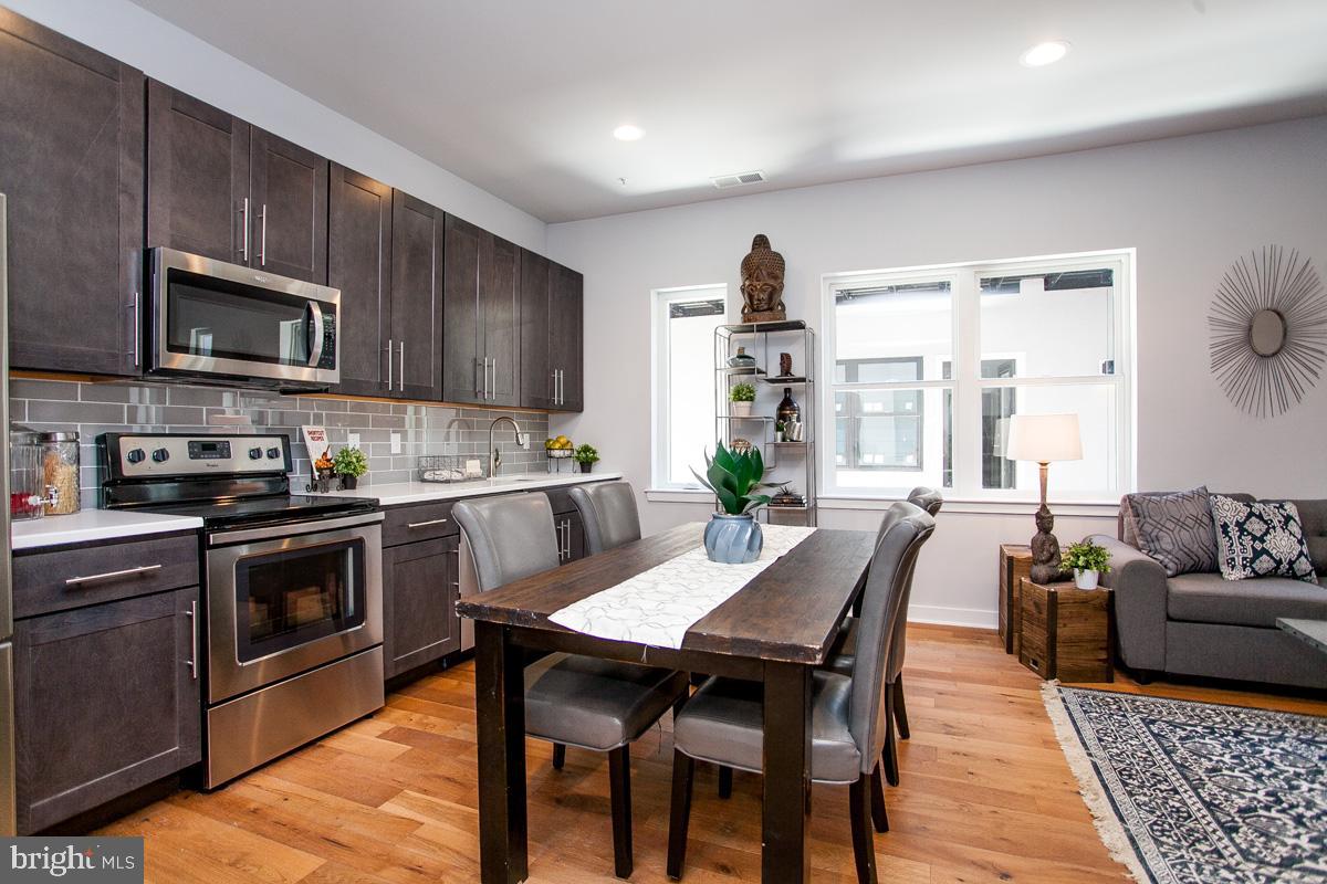 5938 Henry Avenue, Unit 21 Philadelphia, PA 19128 - Photo 3 of 19 a kitchen with a table chairs microwave and cabinets