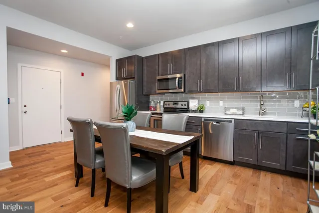 a kitchen with a table chairs refrigerator and cabinets
