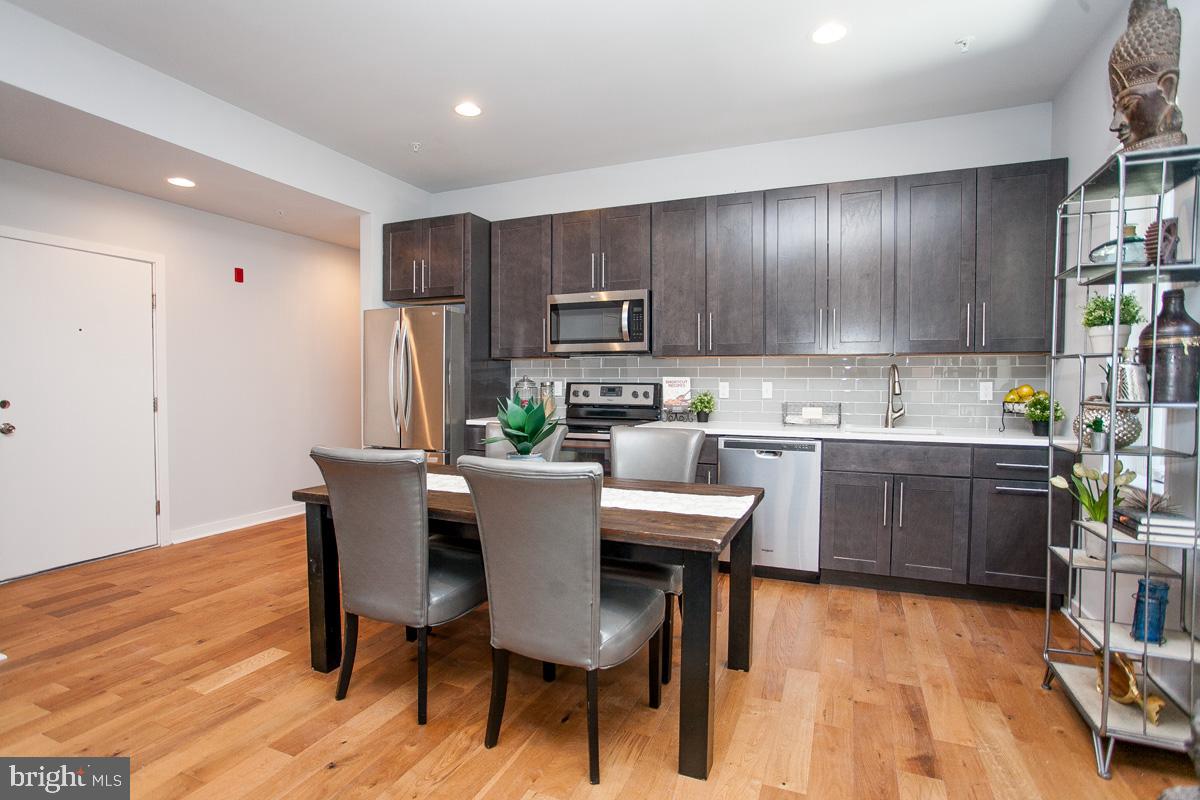 5938 Henry Avenue, Unit 21 Philadelphia, PA 19128 - Photo 5 of 19 a kitchen with a table chairs refrigerator and cabinets