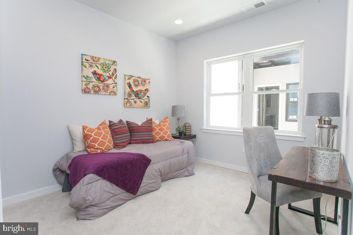 5938 Henry Avenue, Unit 21 Philadelphia, PA 19128 - Photo 9 of 19 a spacious bedroom with a bed and a table
