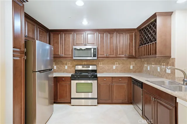 a kitchen with stainless steel appliances granite countertop a refrigerator sink and stove