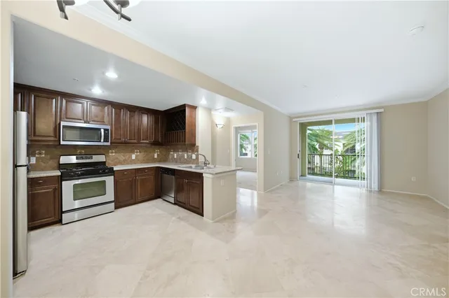 a large kitchen with stainless steel appliances granite countertop a stove refrigerator sink and cabinets