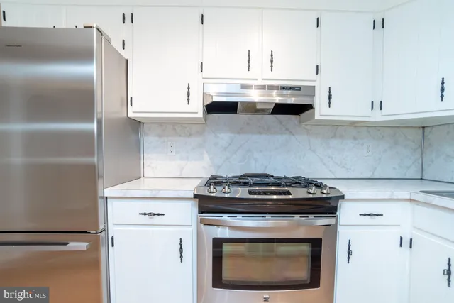 a stove top oven sitting inside of a kitchen