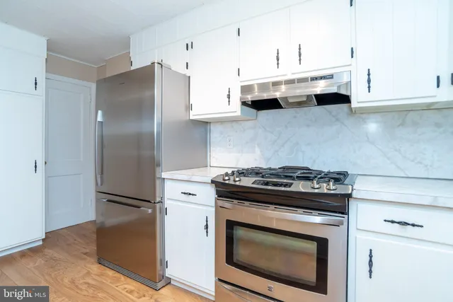 a stove top oven sitting inside of a kitchen