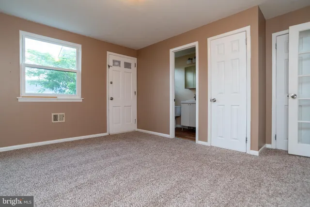 an empty room with windows and closet