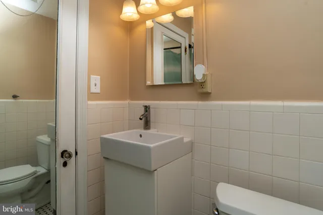 a bathroom with a toilet sink and mirror