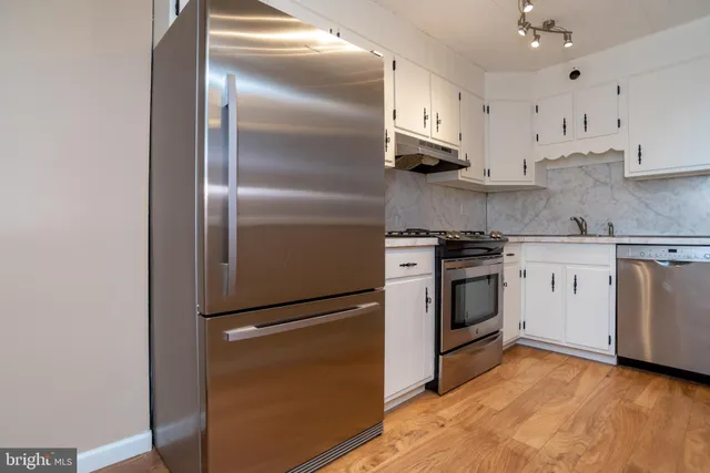 a kitchen with stainless steel appliances white cabinets and a sink