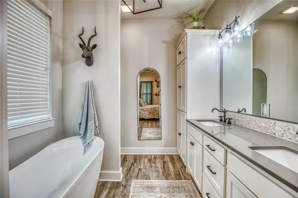 a bathroom with a tub sink and mirror