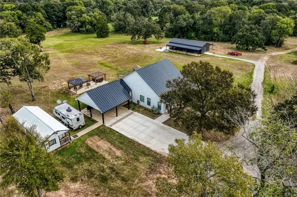 an aerial view of a house with swimming pool and garden