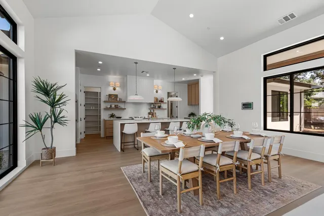 a kitchen with granite countertop a table chairs stove a sink and dishwasher with wooden floor