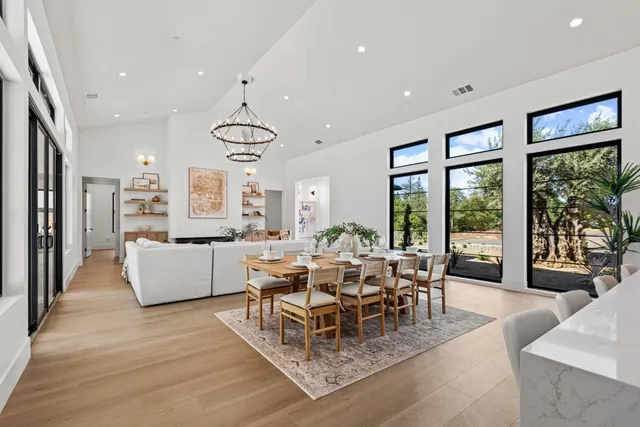 a kitchen with stainless steel appliances a stove a sink a island and chairs with wooden floor