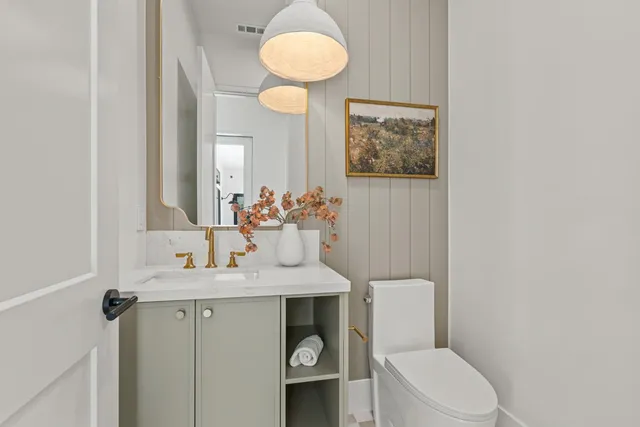 a bathroom with a double vanity sink toilet mirror and bathtub