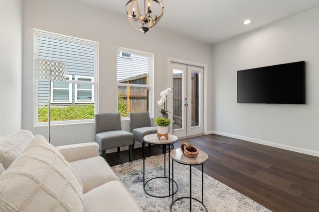 a living room with furniture a flat screen tv and a large window