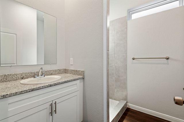 a bathroom with a granite countertop sink and a mirror