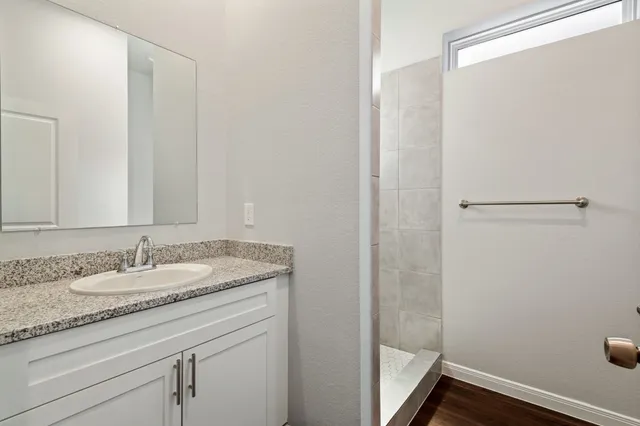 a bathroom with a granite countertop sink and a mirror
