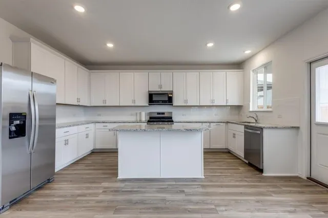 a kitchen with a refrigerator stove top oven and sink
