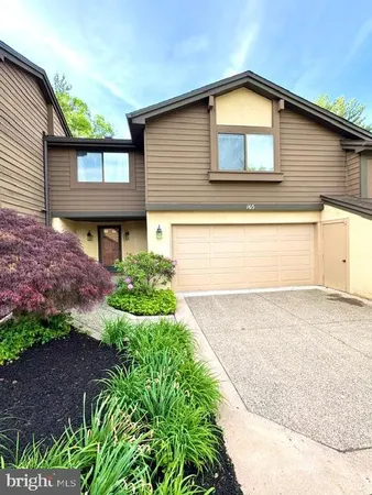 a front view of a house with a yard and a garage