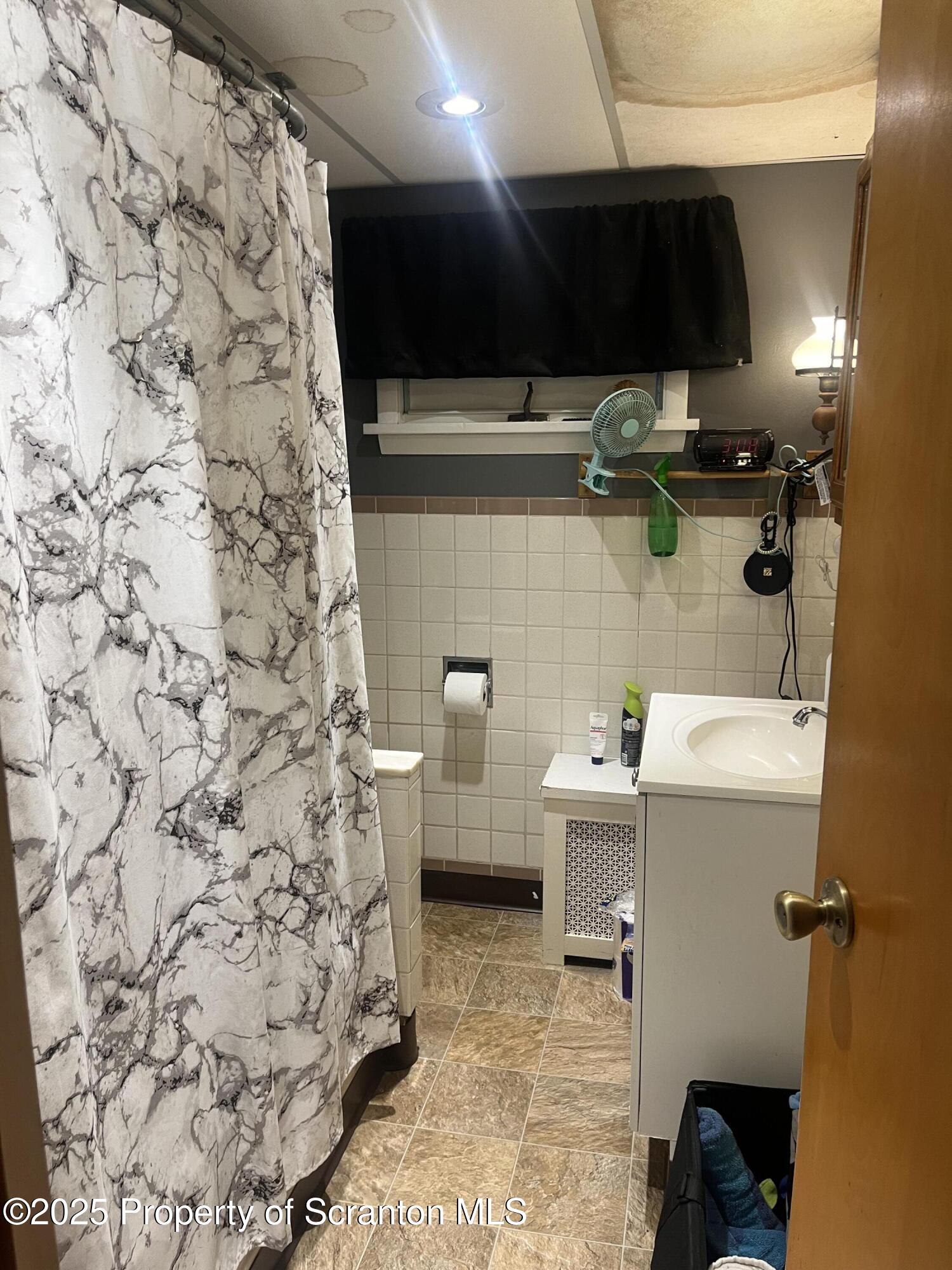 108 3rd Street Blakely, PA 18447 - Photo 11 of 27 a bathroom with a sink a toilet and shower