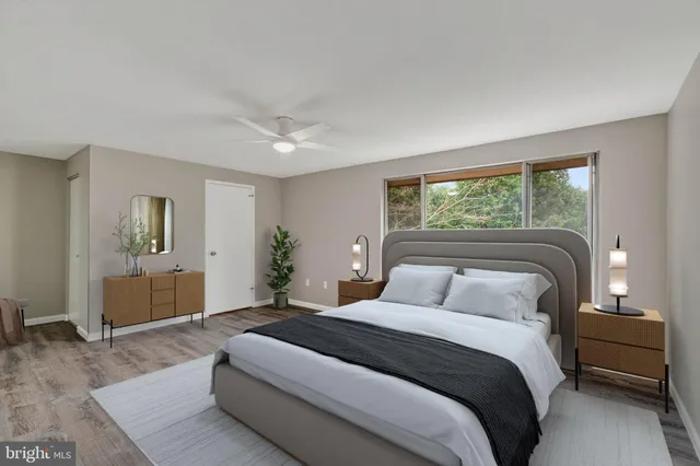 a bedroom with a large bed chandelier and a window