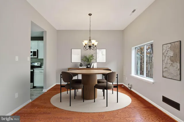 a dining room with furniture a chandelier and wooden floor