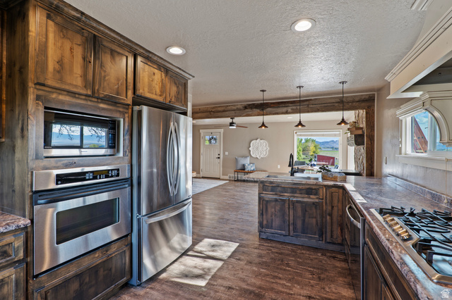 115 East 1600th Street North Santaquin, UT 84655 - Photo 8 of 52 Kitchen featuring wood cabinetry, stainless steel appliances, a built-in oven and microwave, and wood-finish flooring