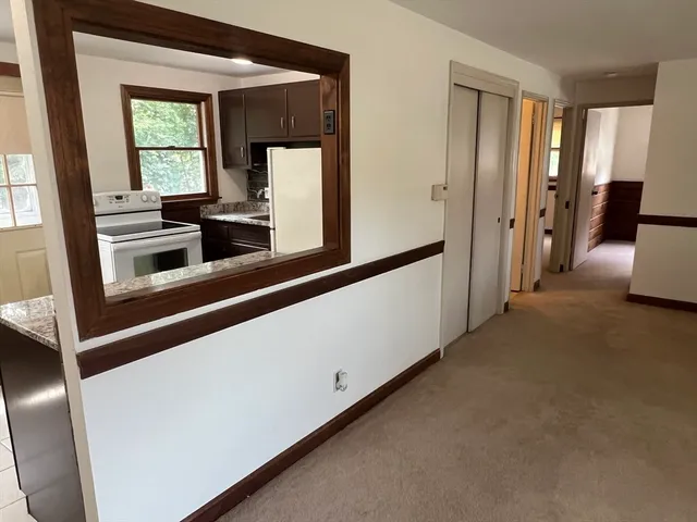 a view of a hallway with furniture and a window