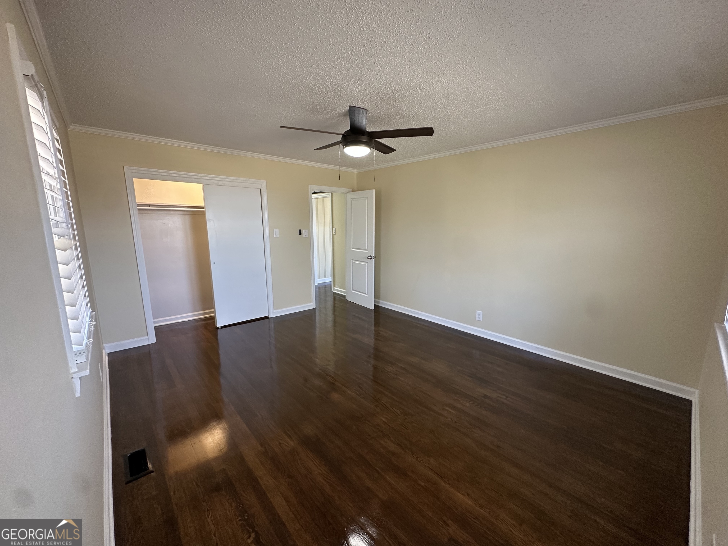 306 Garner Street Thomaston, GA 30286 - Photo 32 of 59 an empty room with wooden floor ceiling fan and windows