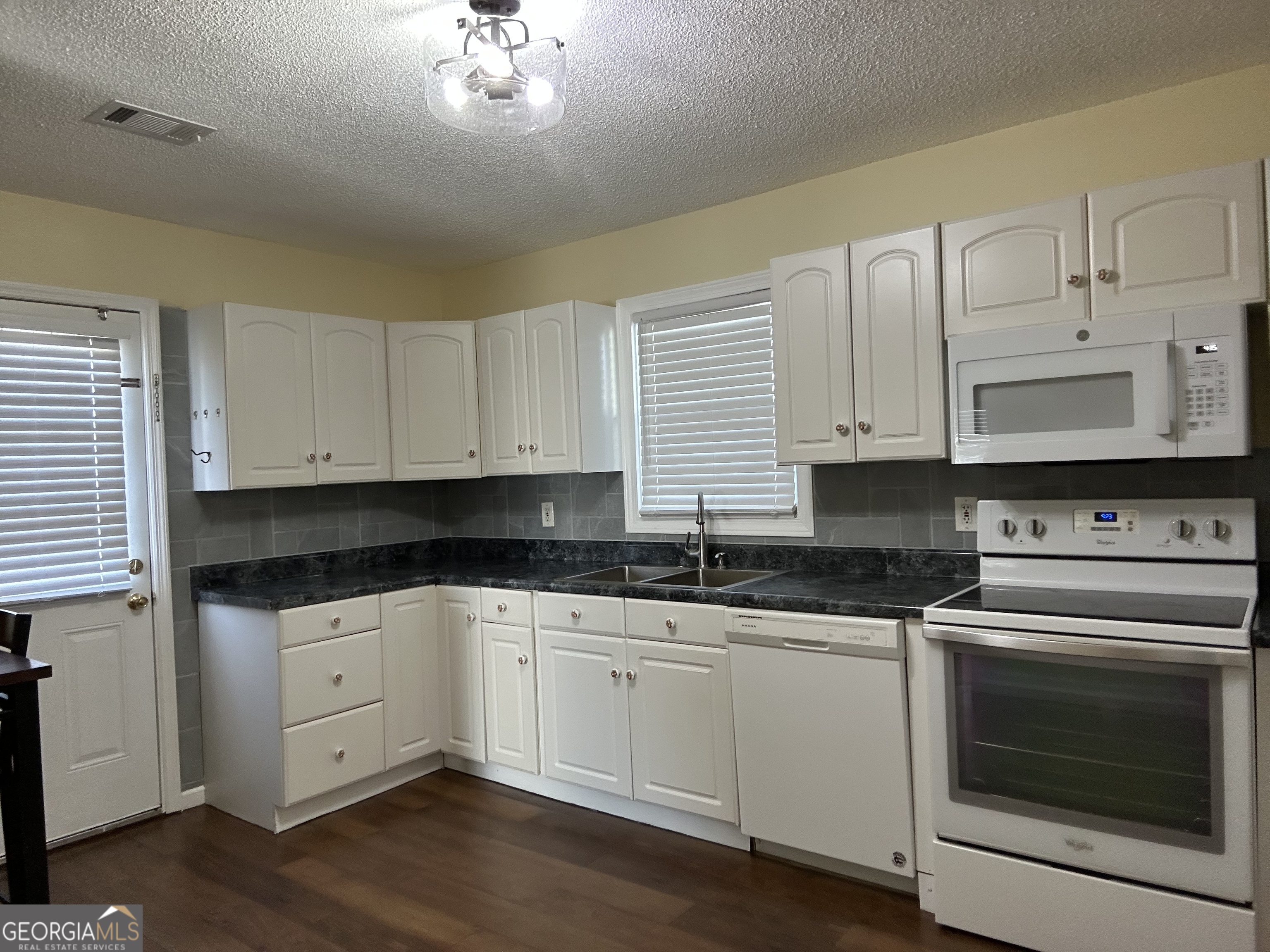 306 Garner Street Thomaston, GA 30286 - Photo 52 of 59 a kitchen with granite countertop a sink cabinets and stainless steel appliances