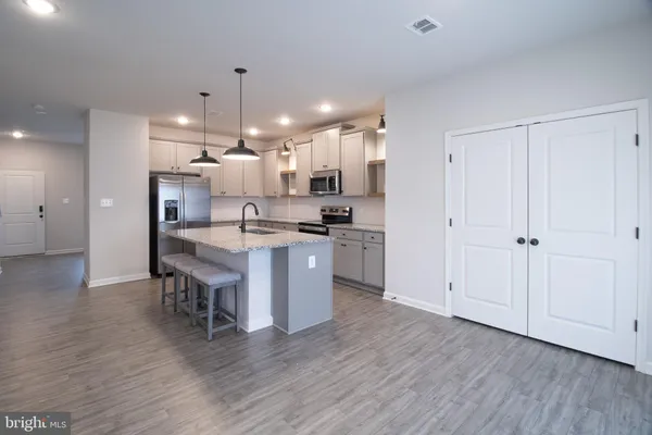 a kitchen with stainless steel appliances granite countertop a sink a stove and a refrigerator