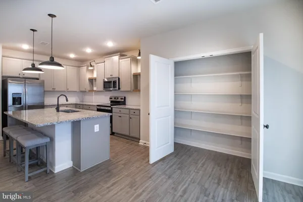 a kitchen with stainless steel appliances granite countertop a sink a stove a microwave a center island and cabinets