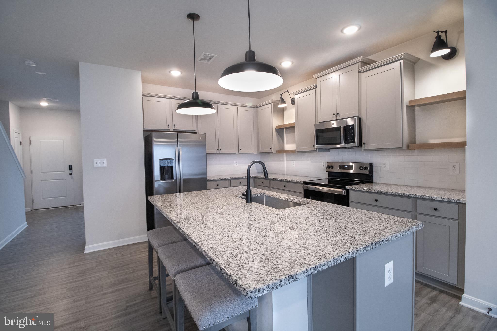 154 Diving Scaup Road Hedgesville, WV 25427 - Photo 19 of 57 a kitchen with kitchen island granite countertop a sink a center island and stainless steel appliances