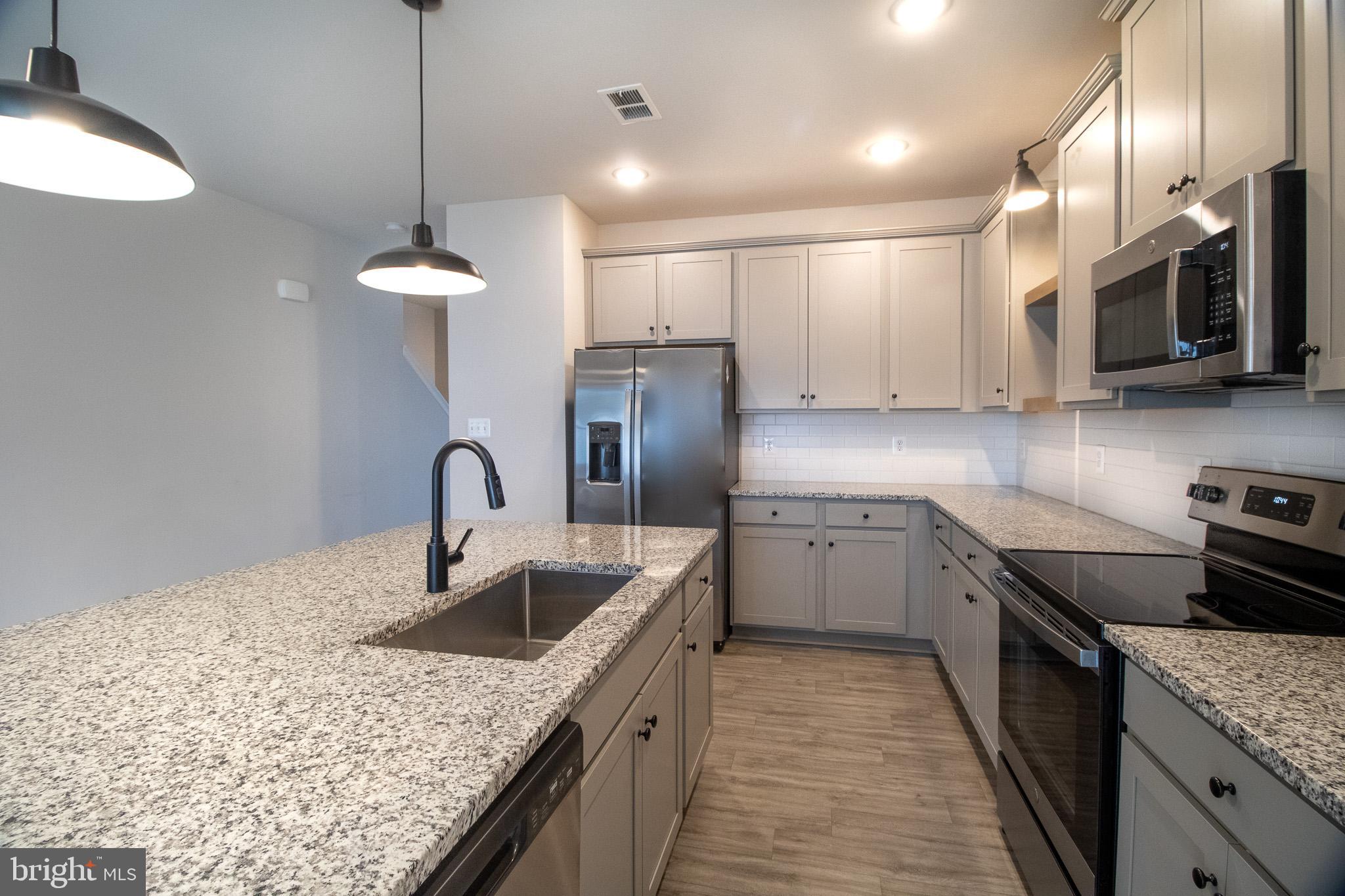 154 Diving Scaup Road Hedgesville, WV 25427 - Photo 20 of 57 a kitchen with stainless steel appliances granite countertop a sink a stove and a refrigerator