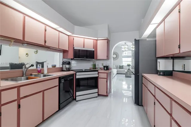 a kitchen with stainless steel appliances granite countertop a sink dishwasher stove and refrigerator