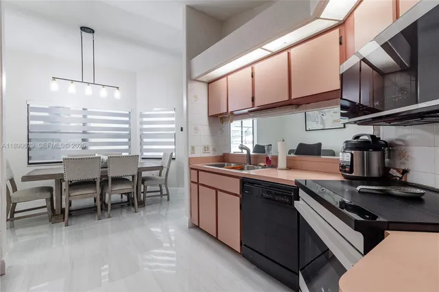 a kitchen with stainless steel appliances granite countertop a sink a stove and a refrigerator