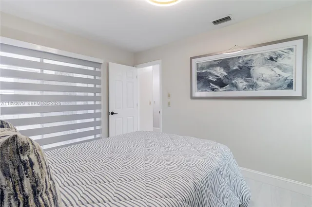 a bedroom with a bed and a wall painting