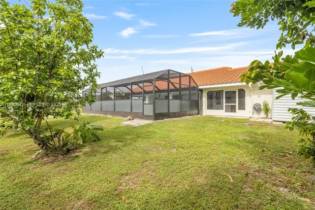 an aerial view of a house with a garden and lake view