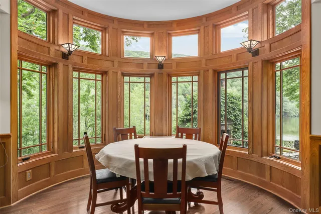 a view of a dining room with furniture large windows and wooden floor