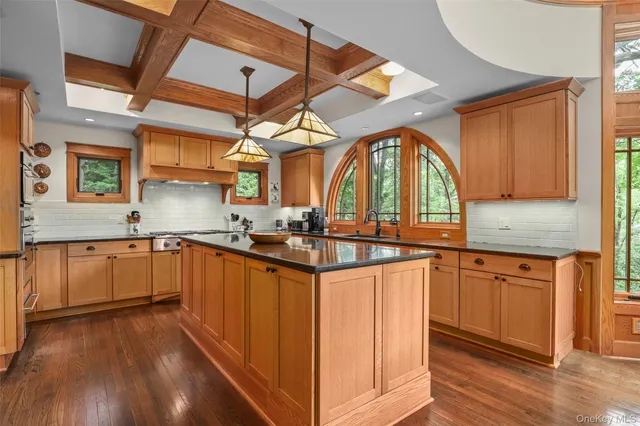 a kitchen with granite countertop a sink cabinets and wooden floor