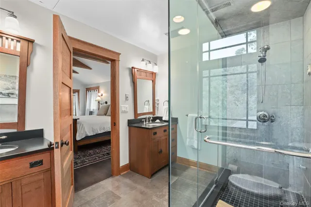 a bathroom with a tub a double vanity sink a mirror and a shower